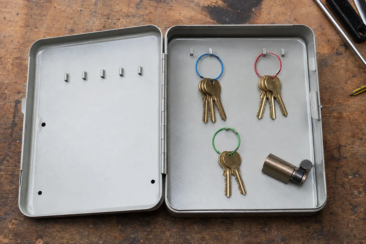 Three groups of keys on colored rings in an open metal key cabinet. — Master Key System Design, Caledon